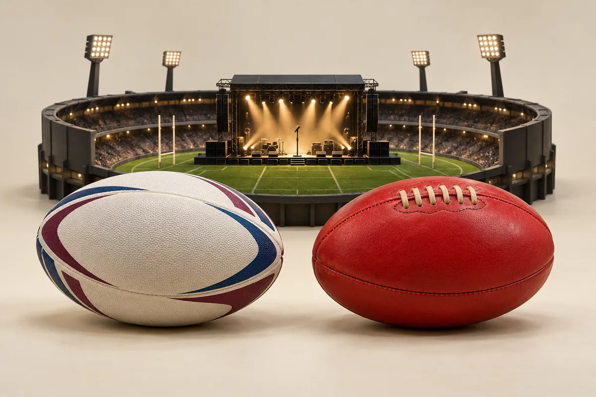 A white rugby league ball and red Australian rules footy beside a miniature stadium concert stage